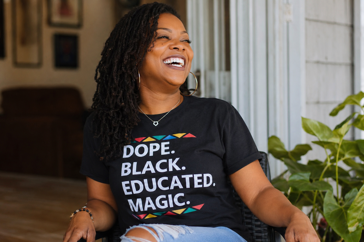Women smiling and wearing a t-shirt that says "Dope. Black. Educated. Magic.".