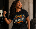 Person wearing a black t-shirt with 'Losing is Learning!' text, standing against a neutral background.