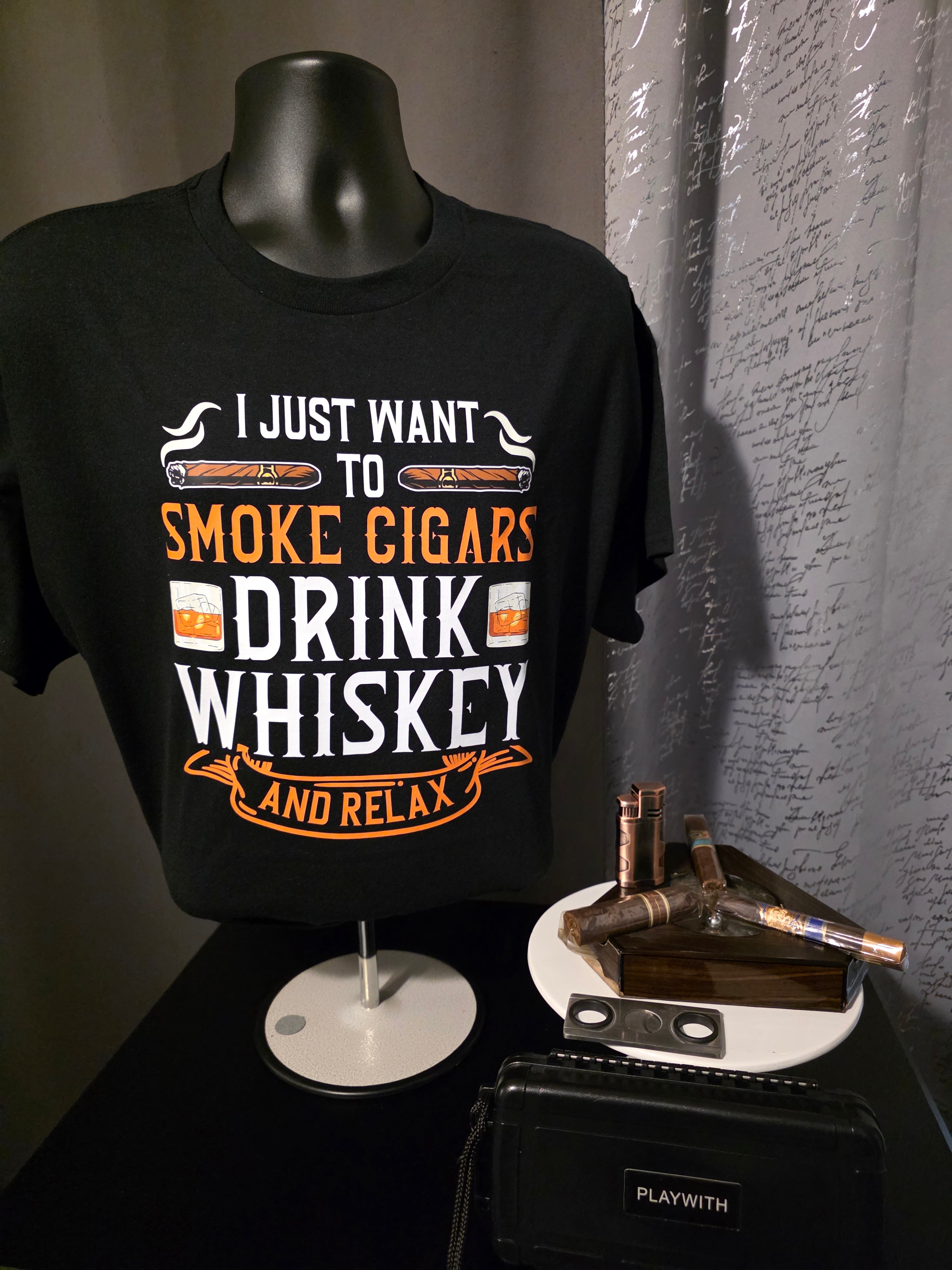 Black bottle with text 'I just want to smoke cigars, drink whiskey and relax' next to a cigar and whiskey bottle.